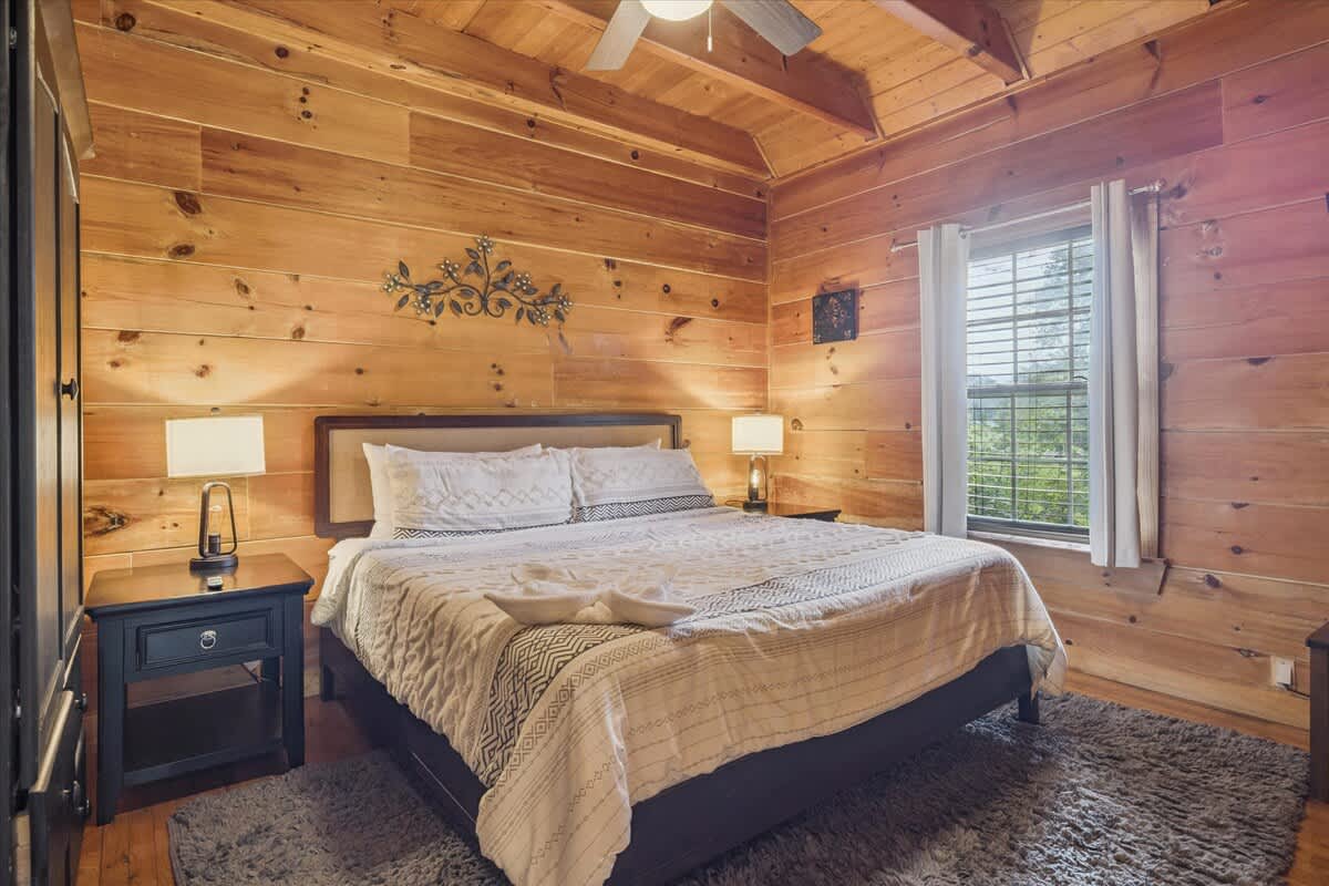 Bedroom Retreat: Embrace rustic charm with wooden walls and soft, inviting linens!