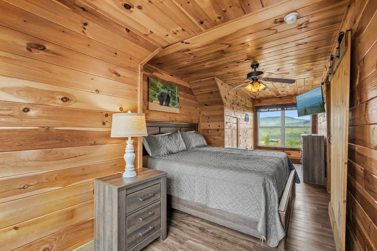 Bedroom Retreat: Relax in this charming wood-paneled haven with stunning mountain views!