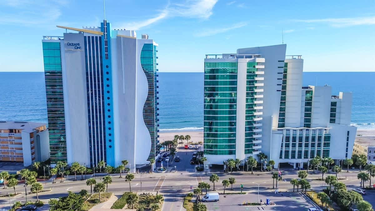 - Oceanfront resort building exterior featuring tall windows and unique blue trim   - Modern architecture highlights Myrtle Beach skyline with contemporary coastal look   - Vacation stay offer