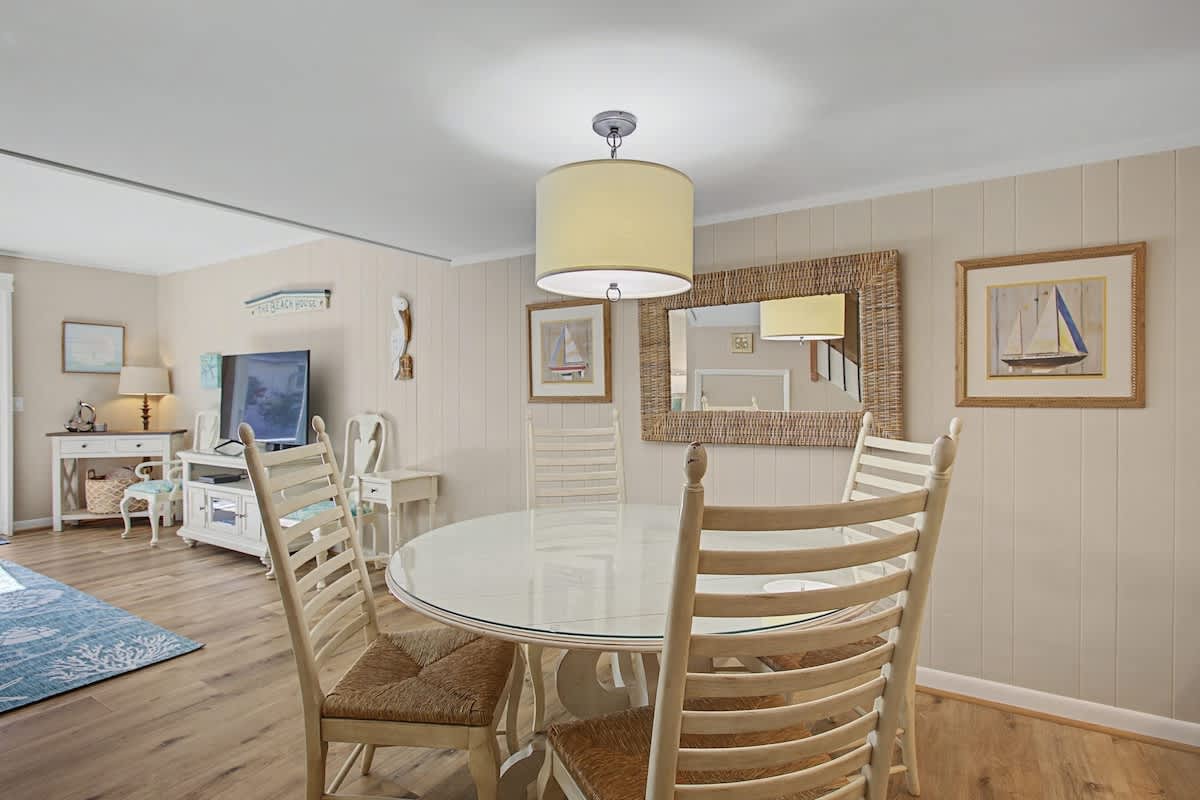 Relax in your coastal-inspired dining space with nautical artwork and warm wood accents creating the perfect atmosphere for memorable meals.