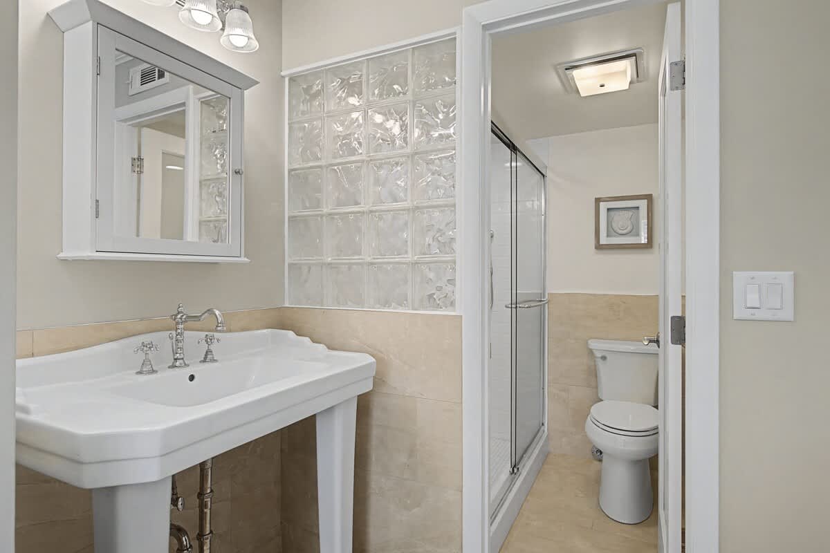 Step into your elegant ensuite bathroom with stylish pedestal sink, spacious glass shower, and tasteful finishes throughout.