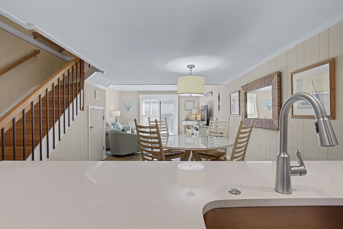 From your kitchen, watch conversations flow between the dining area and living room in this thoughtfully connected coastal space.