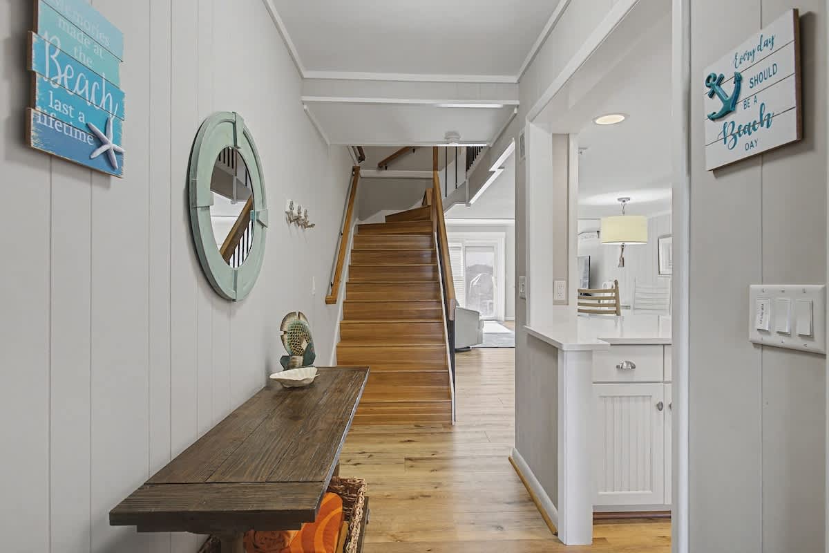 Step into your coastal haven where beach-inspired decor and warm wood floors welcome you home after days of seaside adventures.