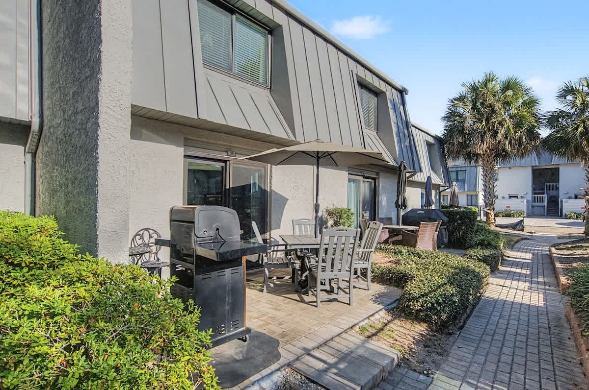 Step onto your private patio where coastal breezes meet BBQ evenings under swaying palms—your perfect outdoor retreat awaits.