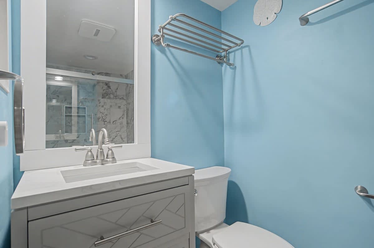 Refresh in your bright, coastal-inspired bathroom featuring modern fixtures and soothing blue walls.