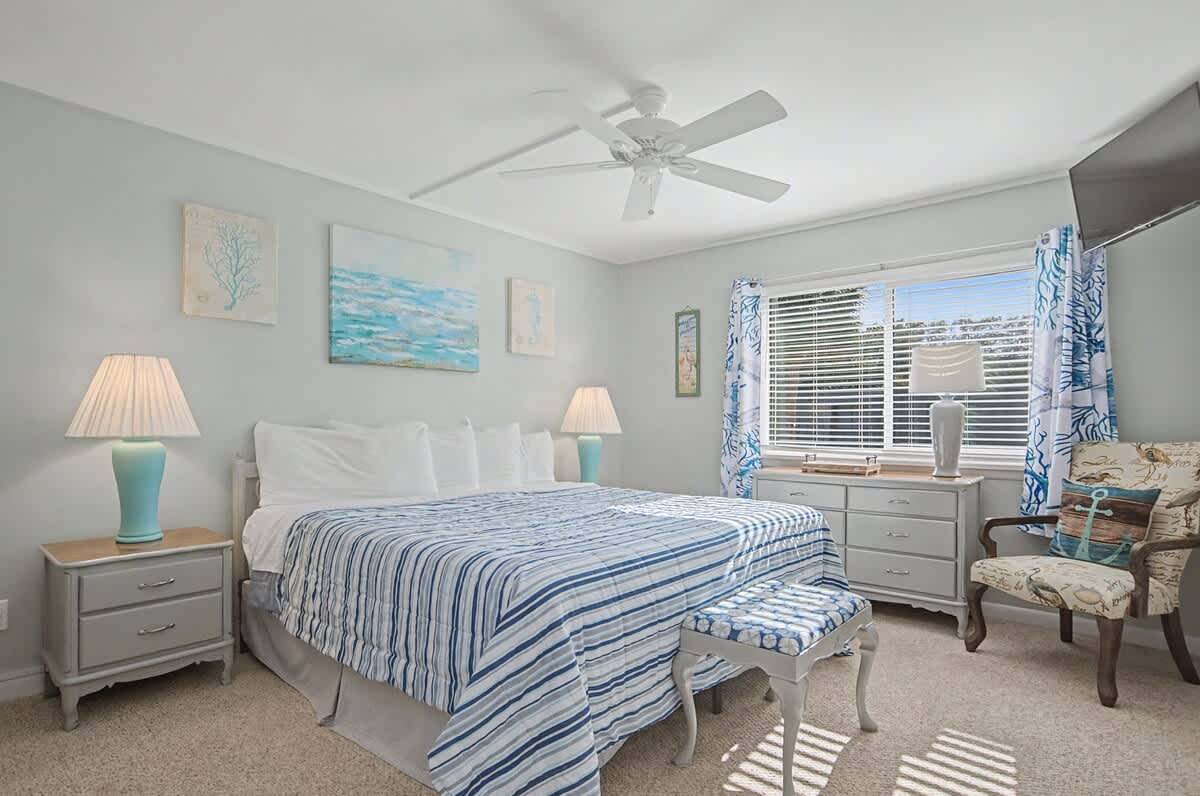 Drift off in your coastal-inspired bedroom, where soothing blues and crisp whites create a serene retreat with ocean artwork adorning the walls.
