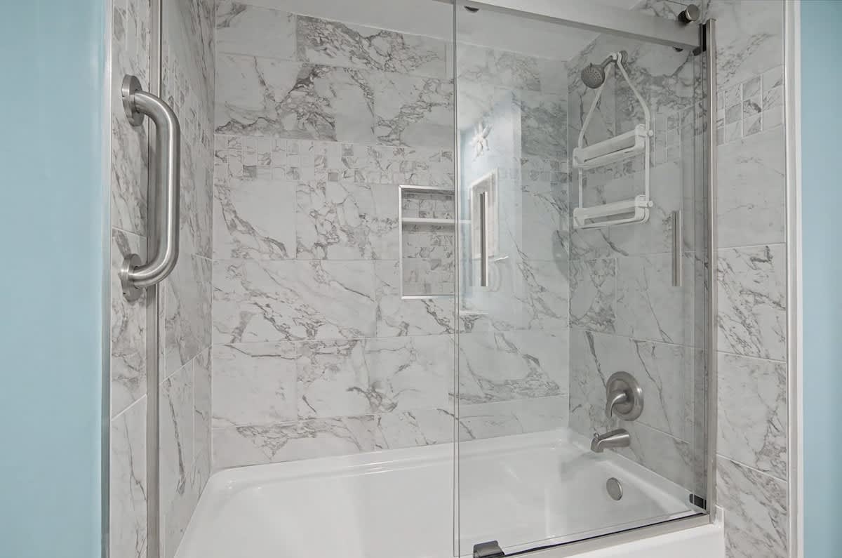 Step into your guest bathroom where luxury meets comfort - a pristine shower-tub combo awaits your relaxation.