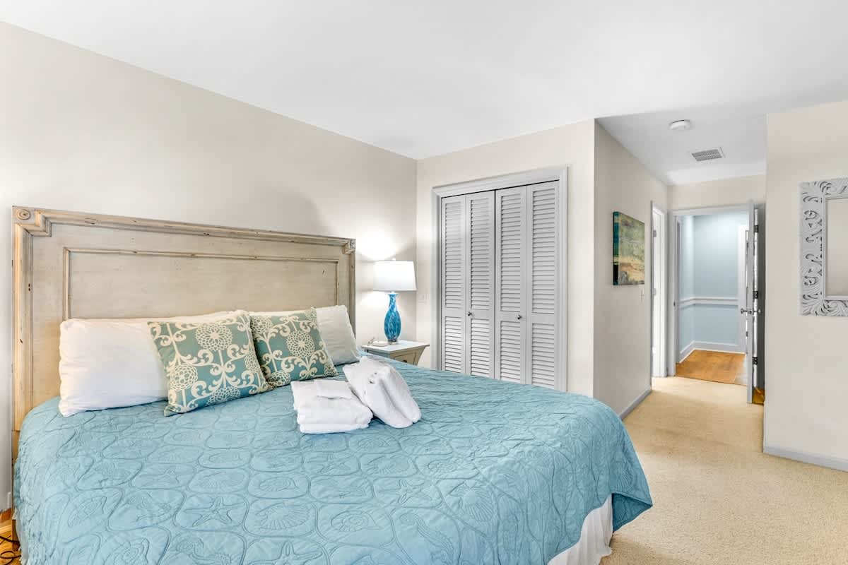 Sink into soft linens and coastal-inspired decor in this peaceful bedroom retreat with ample storage and natural light.