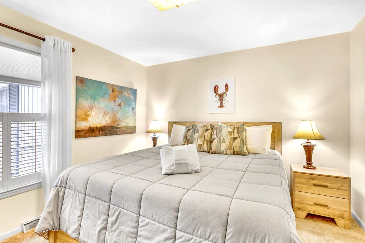 Unwind in your cozy bedroom with coastal artwork and plush bedding for peaceful nights.