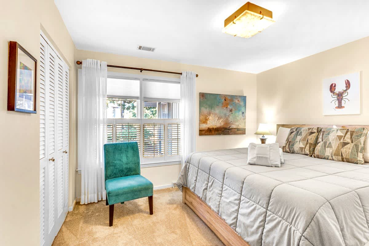 Sink into your plush king bed surrounded by coastal art and natural light streaming through plantation shutters.
