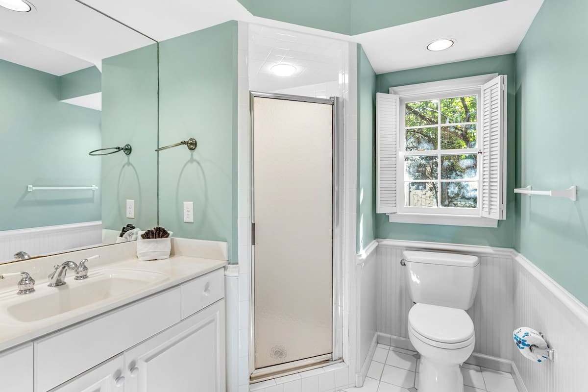 Your spa-inspired bathroom features soothing mint walls, marble counters, and a glass shower where you'll refresh each morning.