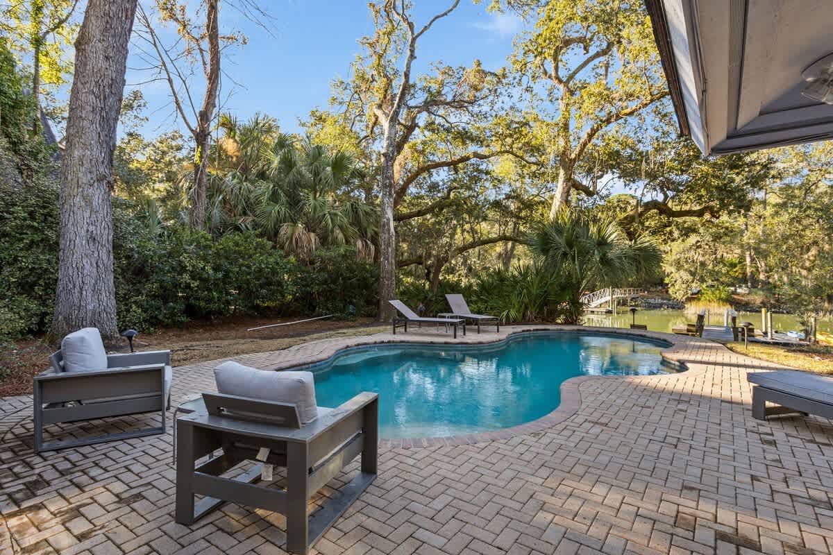 Dive into your private oasis surrounded by towering oaks and palms. Lounge poolside on comfortable chairs while enjoying the peaceful waterfront setting.