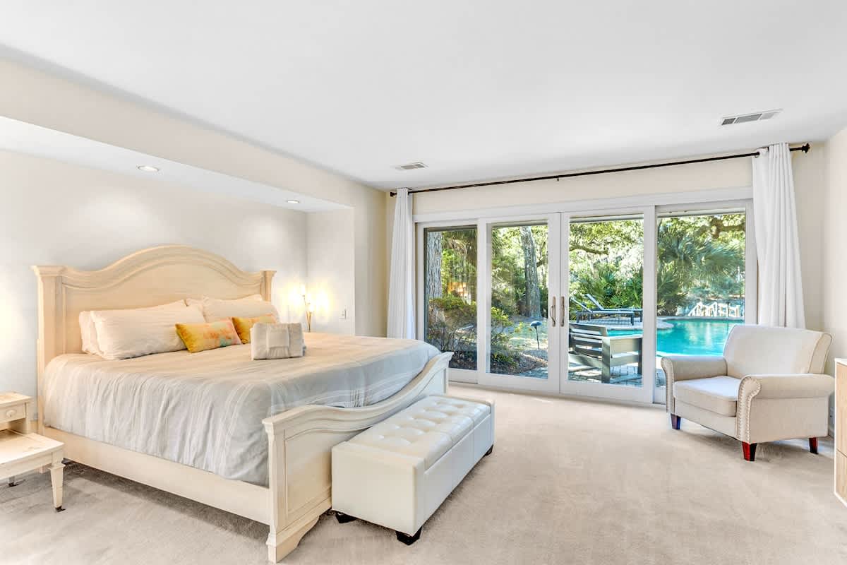 Wake up to pool views from your luxurious master bedroom, where crisp white linens and elegant furnishings create your private sanctuary.