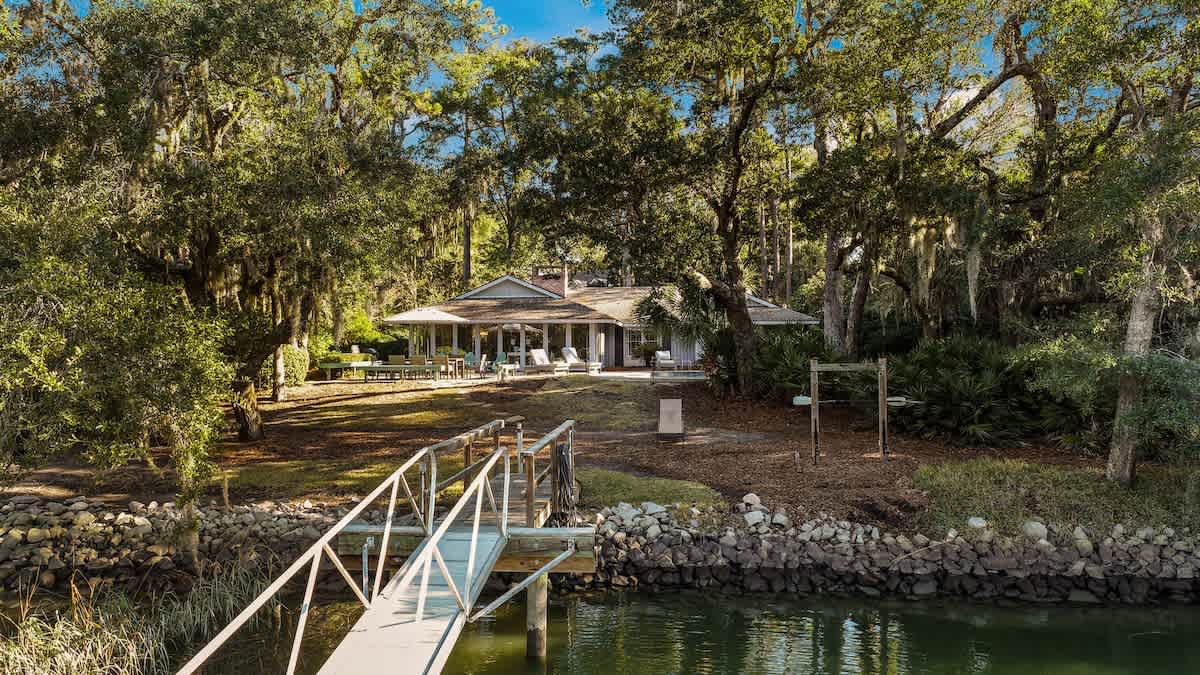 Waterfront retreat with private dock nestled among mature trees, offering serene lakeside tranquility.