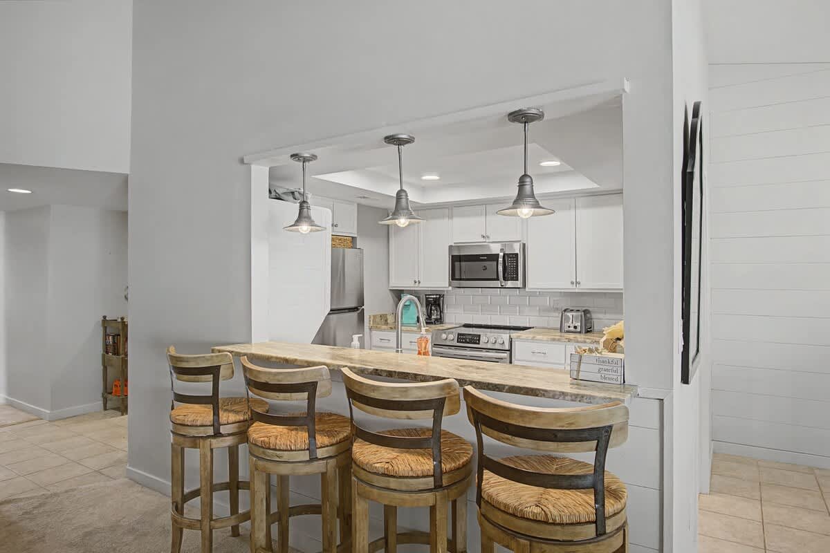 Your fully equipped kitchen features a breakfast bar where you can enjoy morning coffee while planning your day's adventures.