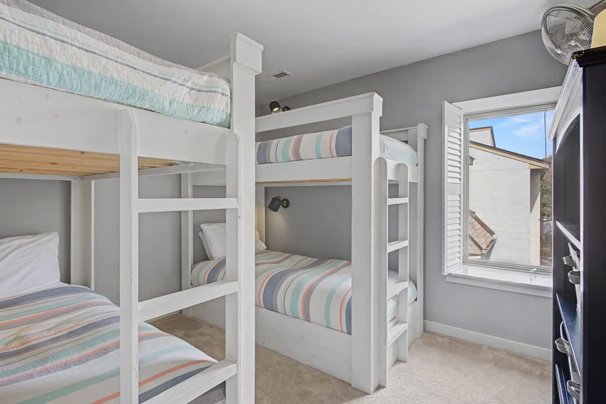 Your group will love these custom bunk beds with individual reading lights and cozy striped linens for perfect shared adventures.