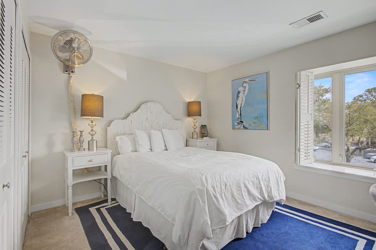 Drift into peaceful dreams in this serene bedroom, where soft white linens and coastal artwork create your perfect seaside retreat.