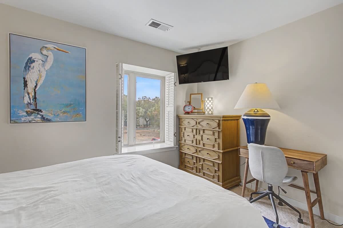 Unwind in your peaceful bedroom featuring coastal artwork, ample storage, and a dedicated workspace for catching up on emails or planning adventures.