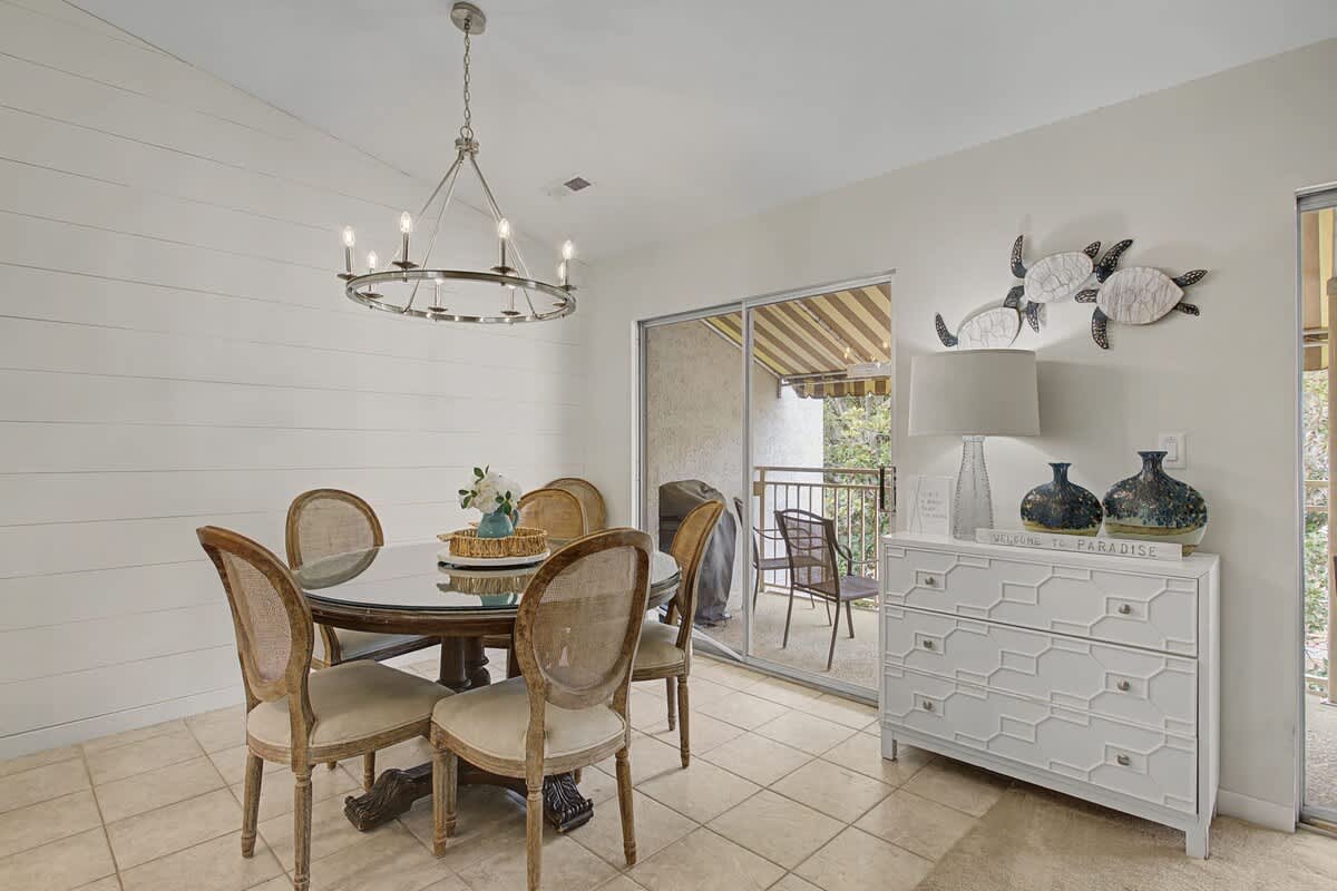 Gather around this elegant dining table where coastal charm meets comfort. The space opens to your private balcony for morning coffee.