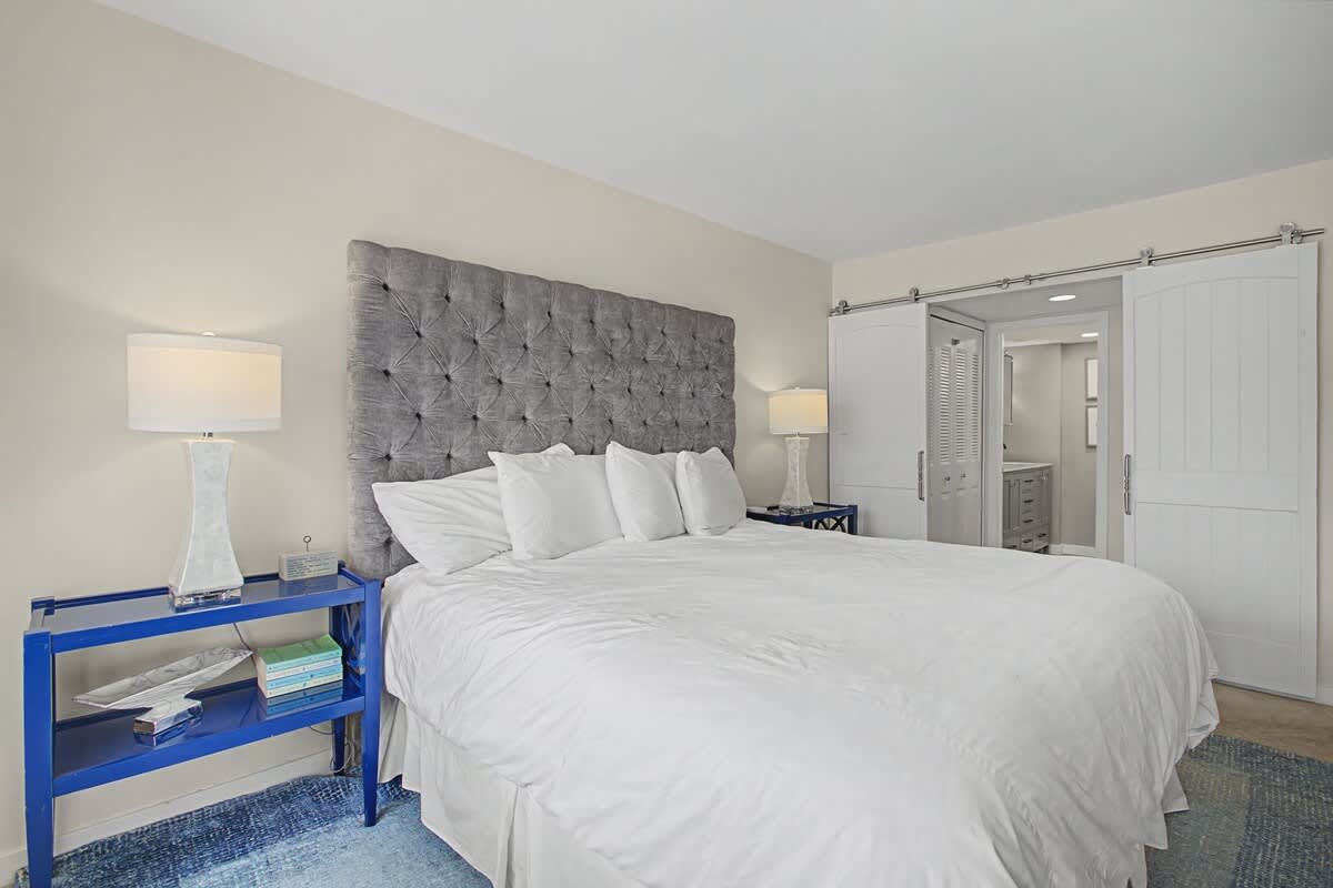 Sink into luxury with crisp white linens and a plush tufted headboard in your peaceful retreat.