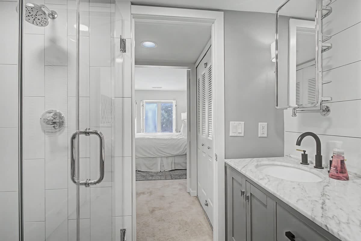 Pamper yourself in this spa-like bathroom with its luxurious marble countertops, spacious glass-enclosed shower, and elegant modern finishes.