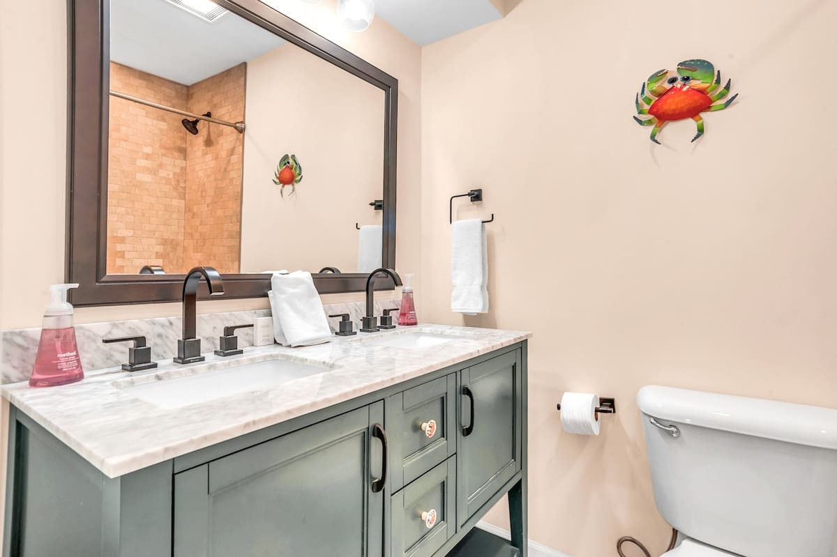 Refresh in your coastal-themed bathroom with dual sinks, marble counters, and charming crab décor that adds personality to your morning routine.
