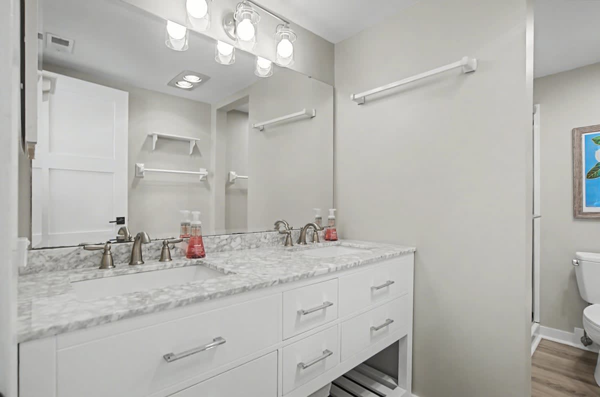 Step into your spa-like bathroom with dual vanities, marble countertops, and warm lighting for your morning routine.