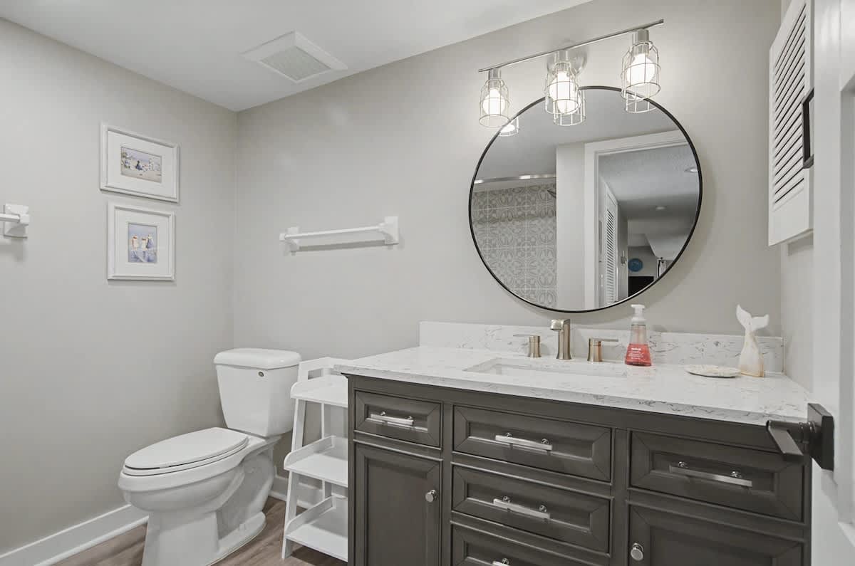 Step into your elegantly appointed bathroom featuring marble countertops, stylish lighting, and thoughtful coastal touches for your daily comfort.