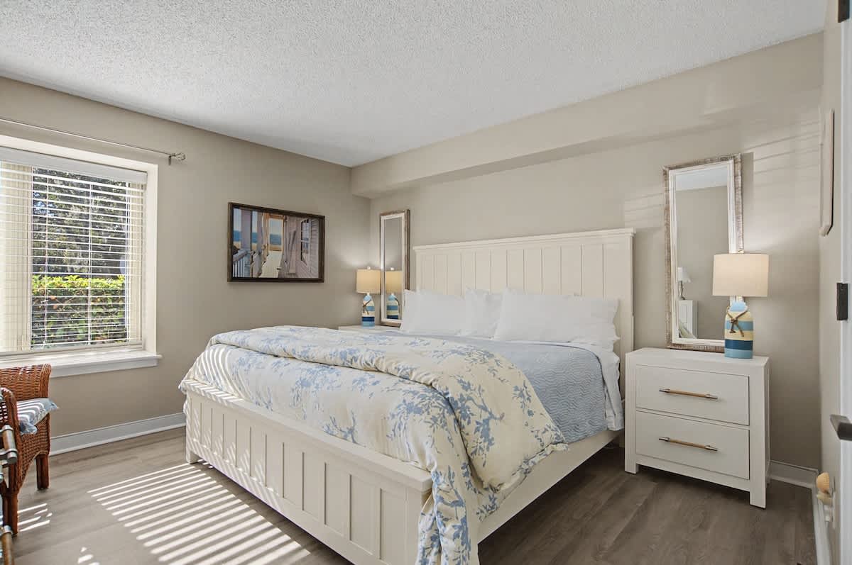 Sink into the comfortable king bed with soft linens in your bright, serene bedroom featuring modern coastal decor and peaceful natural light.