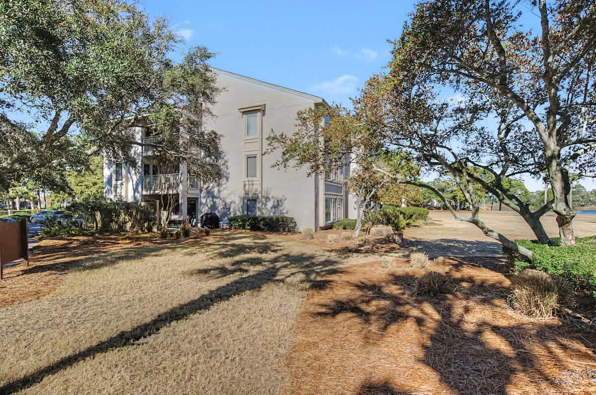 Modern coastal property nestled among mature trees with landscaped grounds and nearby waterfront access.