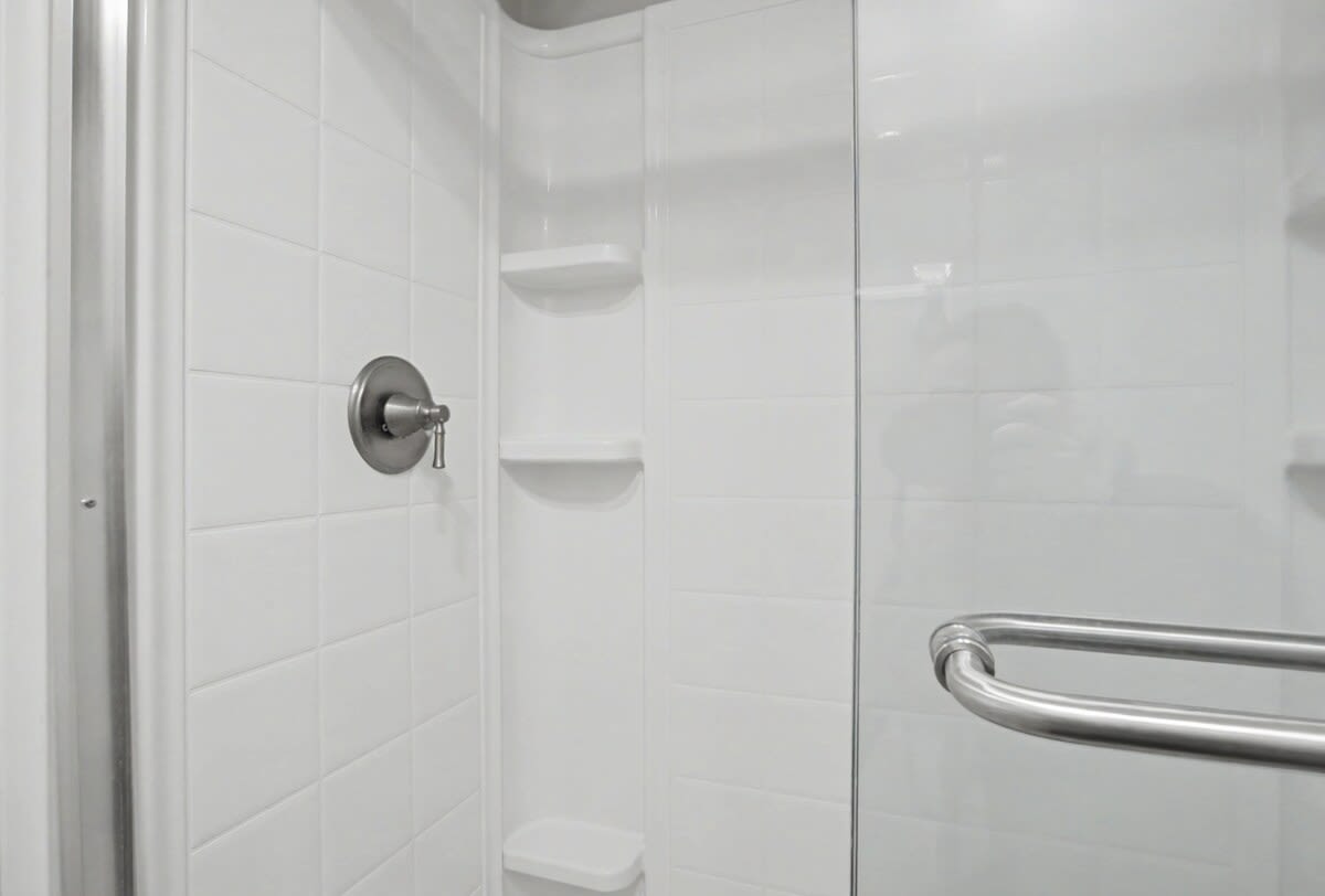 Step into your pristine shower with gleaming white tiles and modern fixtures for a refreshing start to your day.