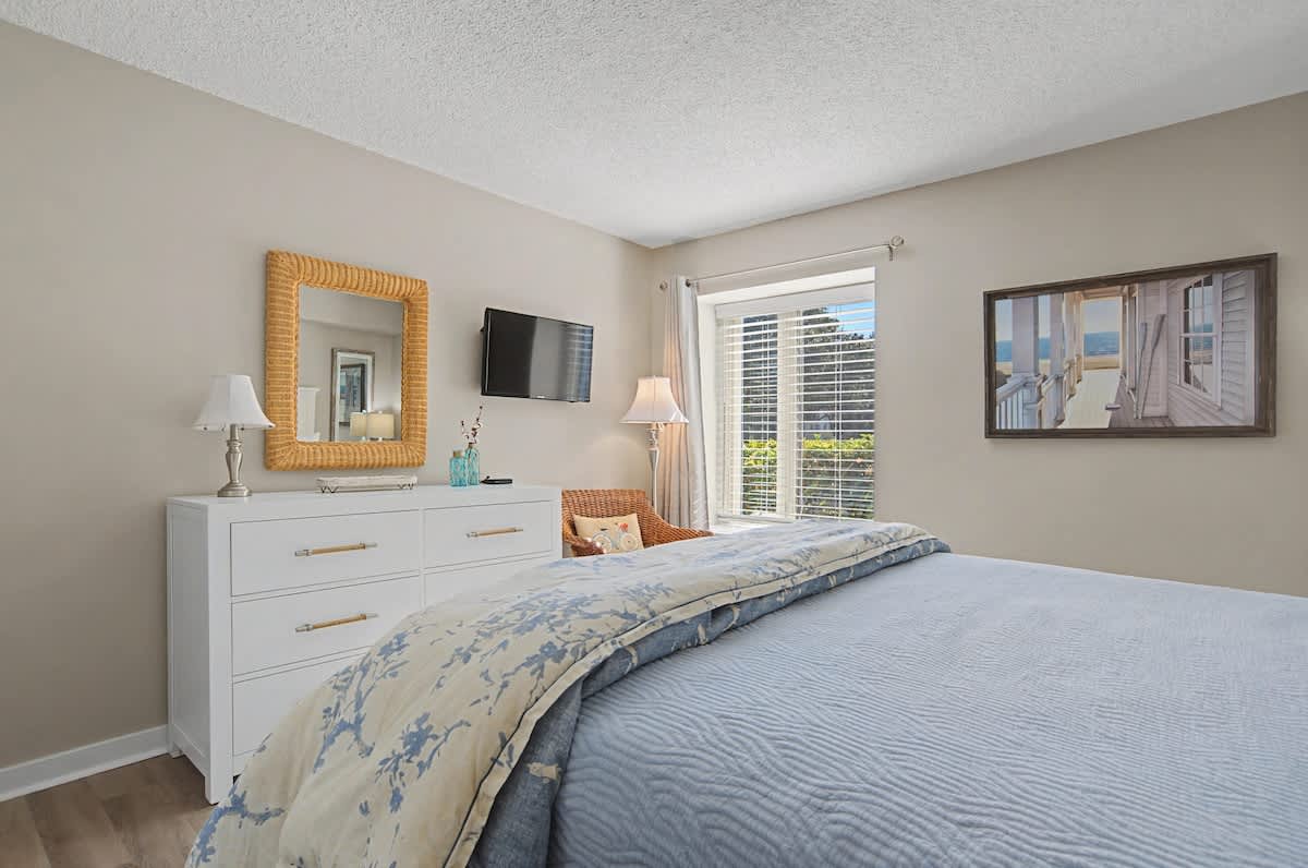 Unwind in your serene bedroom with coastal décor, city views, and crisp linens that promise restful nights.