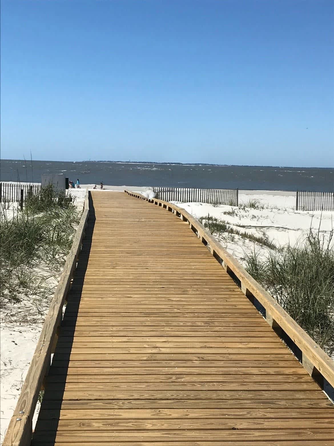 A scenic wooden boardwalk leads directly to pristine beach access, offering stunning coastal views and convenient pathways to sandy shores.