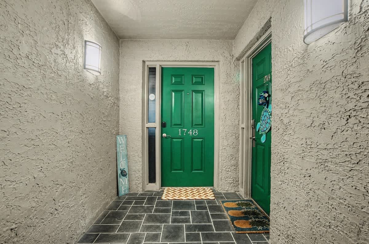 A welcoming entrance with distinctive green doors and charming decorative touches that mark your arrival at this comfortable retreat.