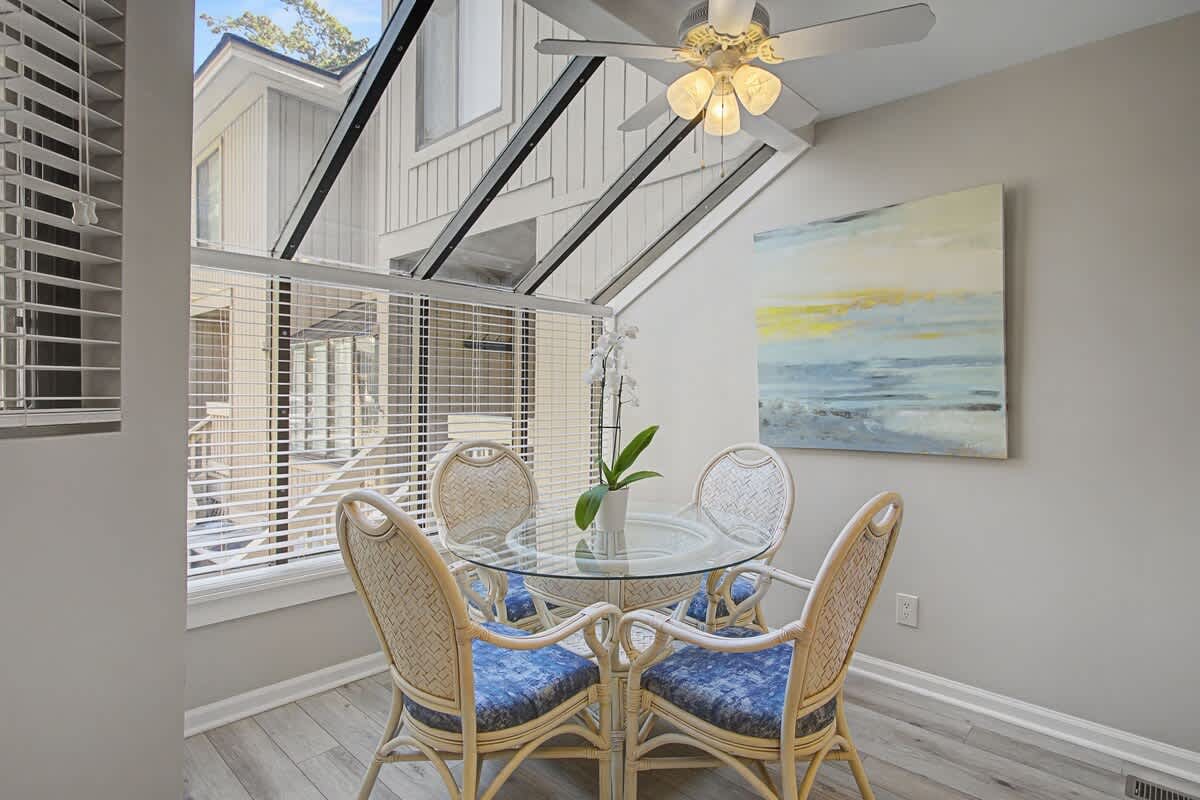 Savor your morning coffee at this charming coastal-themed dining nook with serene artwork and natural light streaming through.