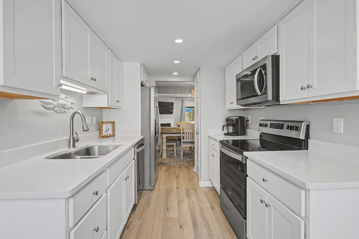 Your bright galley kitchen offers everything you need with modern appliances, ample counter space, and warm wood floors for culinary adventures.