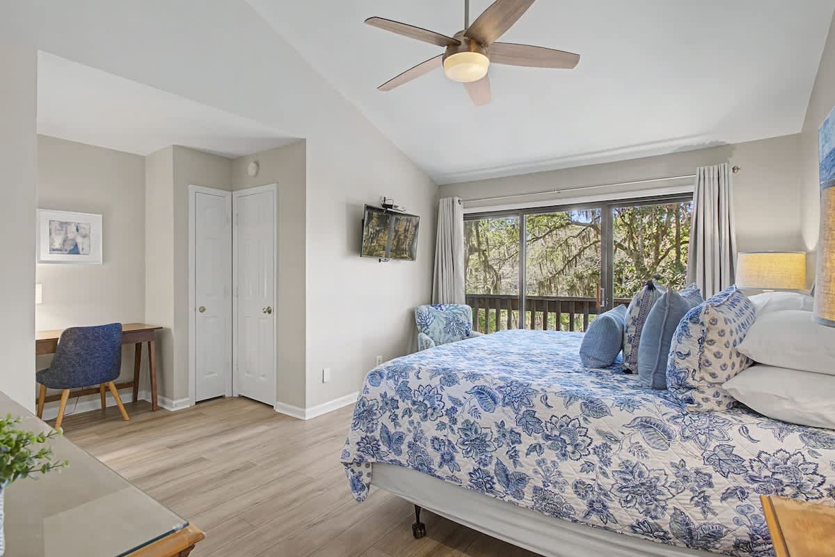 Drift off in your peaceful bedroom with charming blue florals, desk workspace, and leafy views through your private window.
