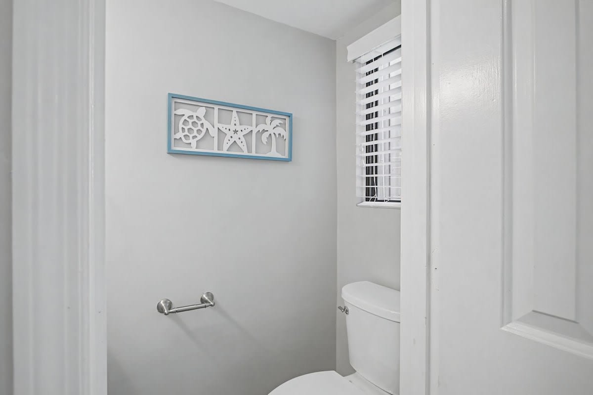 Fresh, clean powder room with nautical accents and private window for your convenience during your stay.