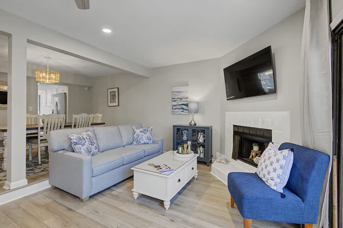 Unwind in your elegant living space with coastal-inspired blues, a cozy fireplace, and open layout perfect for relaxing after your adventures.