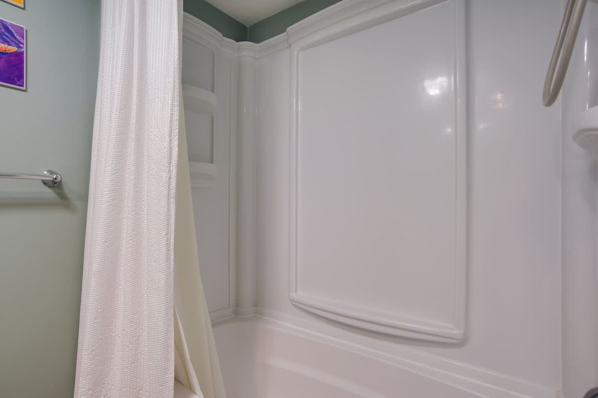 Step into your private bathroom retreat with a pristine white tub perfect for unwinding after exploring.