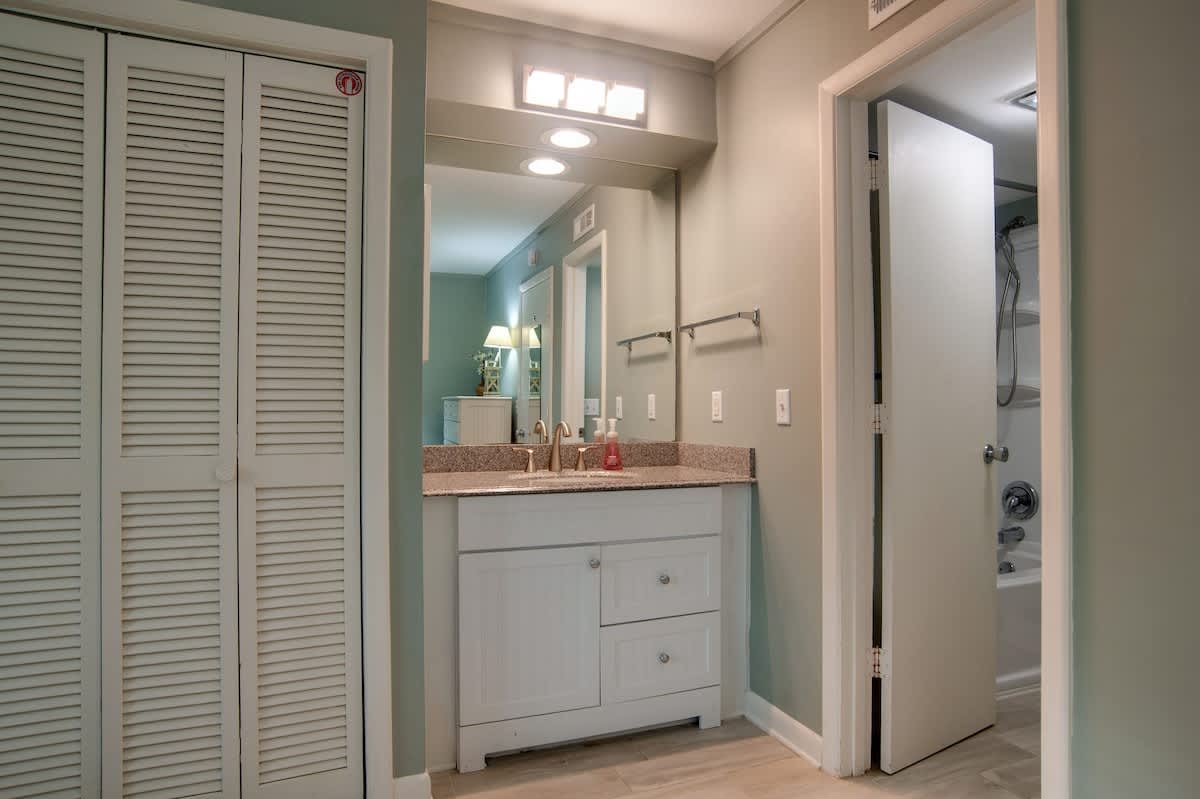 You'll appreciate the coastal-inspired bathroom with granite countertops, ample storage in white louvered closets, and thoughtful lighting for your daily routines.