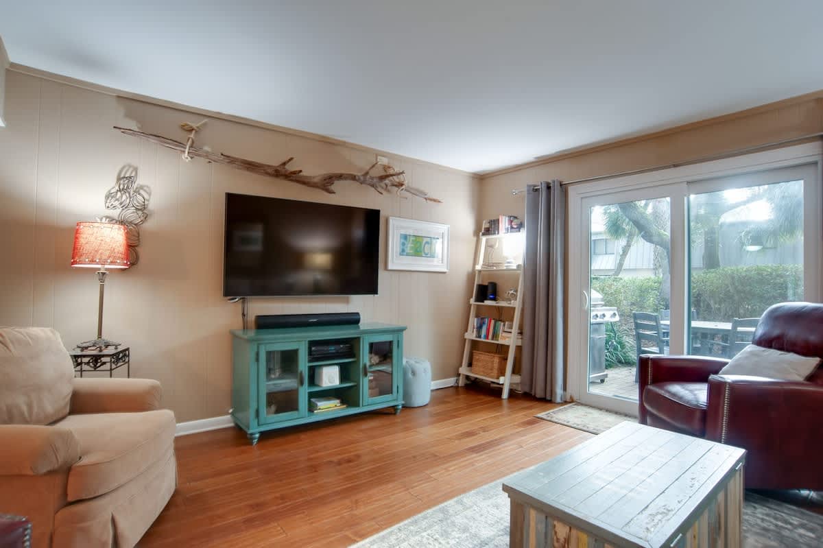 Unwind in your cozy living room with comfortable seating, flat-screen TV, and sliding doors opening to your private outdoor patio space.