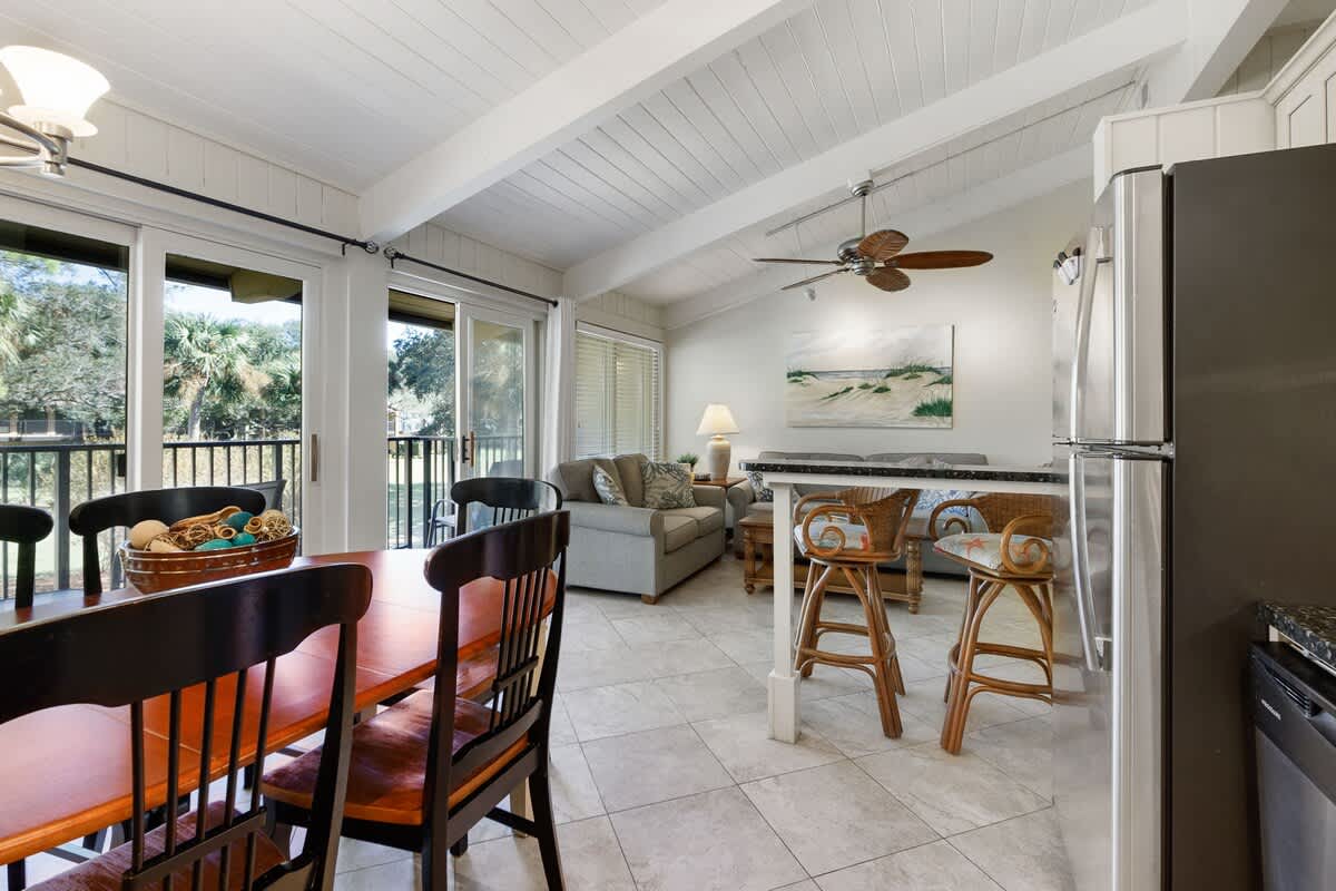 Unwind in your open-concept living space with coastal charm, exposed beams, and a kitchen perfect for vacation meals together.
