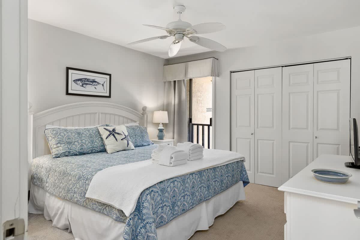Your coastal-themed bedroom awaits with fresh ocean blues, soft linens, and a gentle ceiling fan for peaceful seaside slumber.