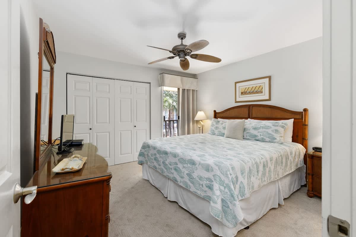 Rest peacefully in your comfortable bedroom with quality wood furnishings, ceiling fan, and natural light streaming through your private window.