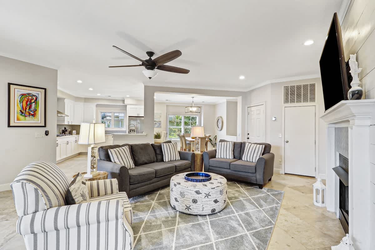 Unwind in your spacious living room featuring plush seating, modern fireplace, and open-concept design flowing seamlessly into the kitchen.