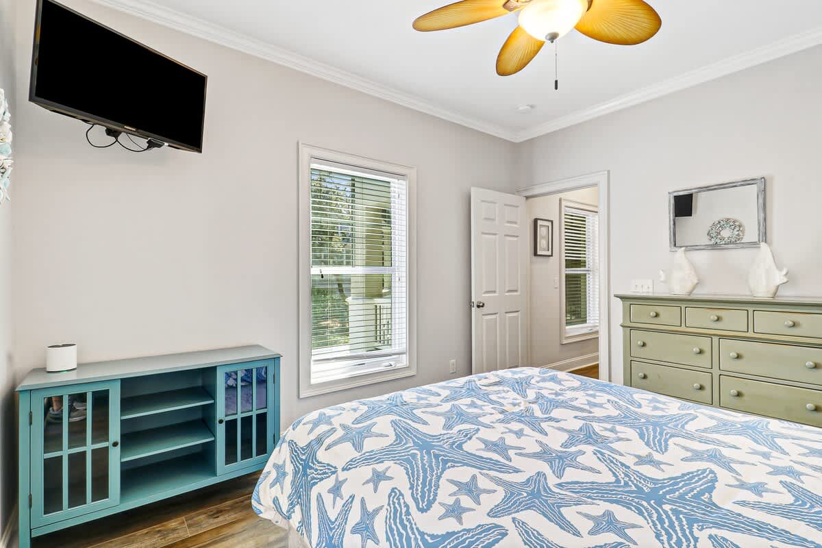 Unwind in your bright coastal bedroom with tropical ceiling fan, flat-screen TV, and charming starfish bedding.