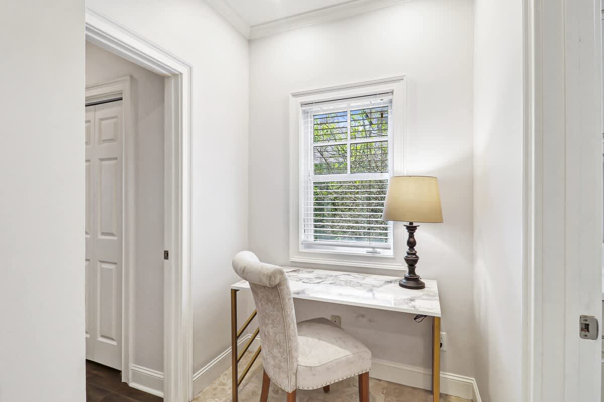 Settle into your elegant workspace featuring a marble-topped desk and plush chair, perfectly positioned by the window for natural inspiration.