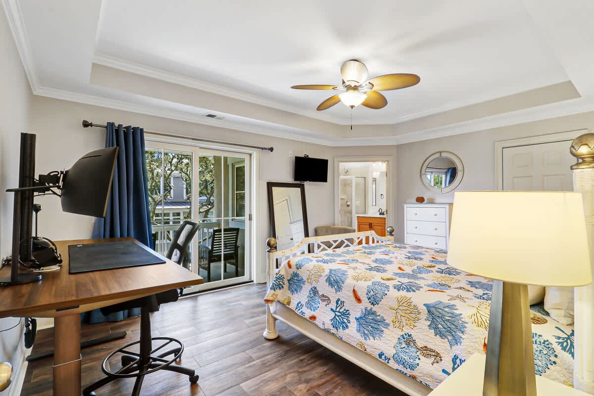 Relax in your bright bedroom with colorful coral bedding, work desk, and balcony access for fresh air.