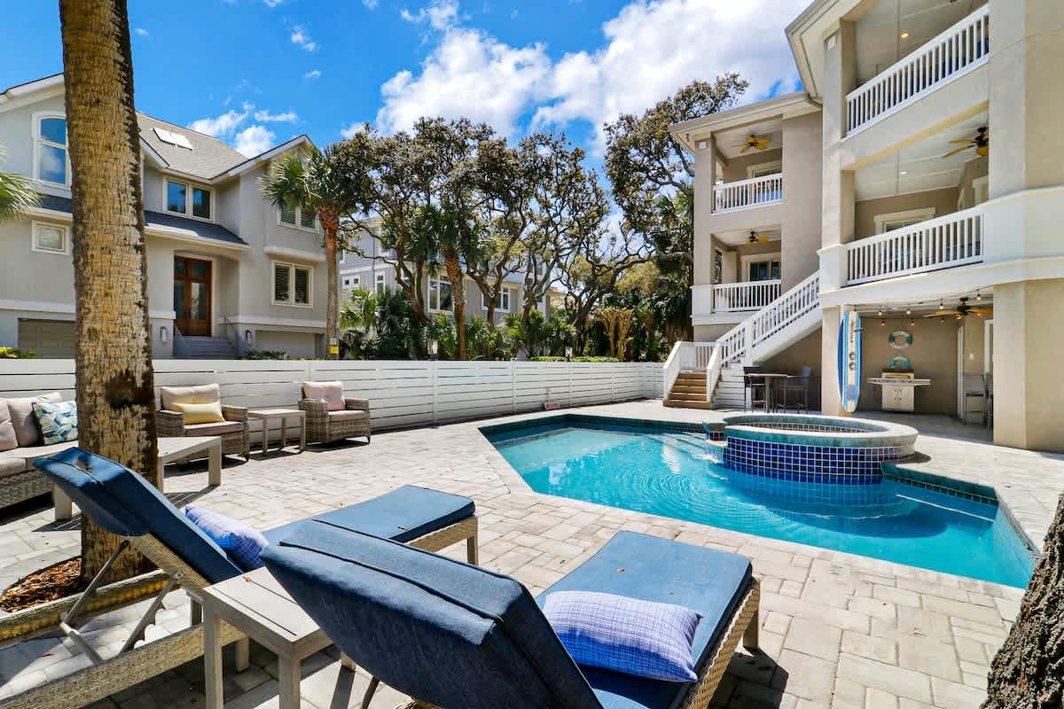 Your private backyard paradise features a sparkling pool and hot tub surrounded by comfortable loungers and seating areas.